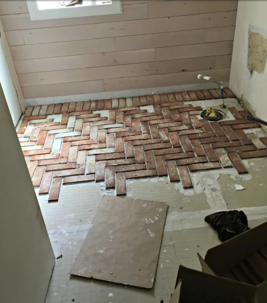 Brick in process of being installed on bathroom floor.