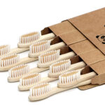Bamboo toothbrushes laying down poking out of the box