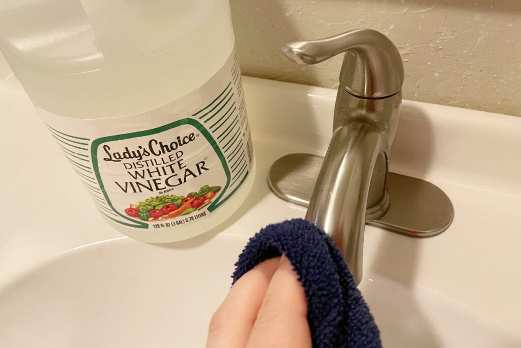Buffing a brushed nickel faucet with a towel and vinegar. 