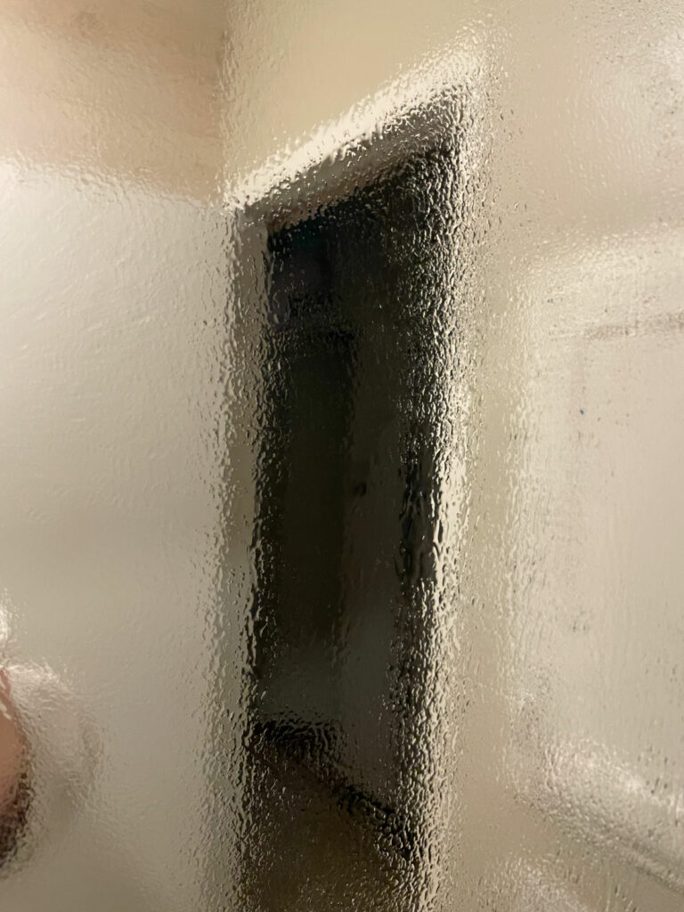 Bathroom mirror covered in steam which is fogging it up. 