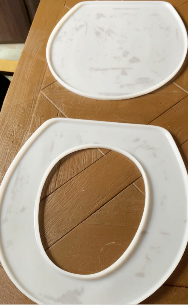 Silicone toilet seat mold on a woo table. 
