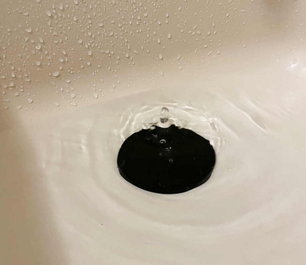 Plastic lid covering a drain hole in a bathtub.